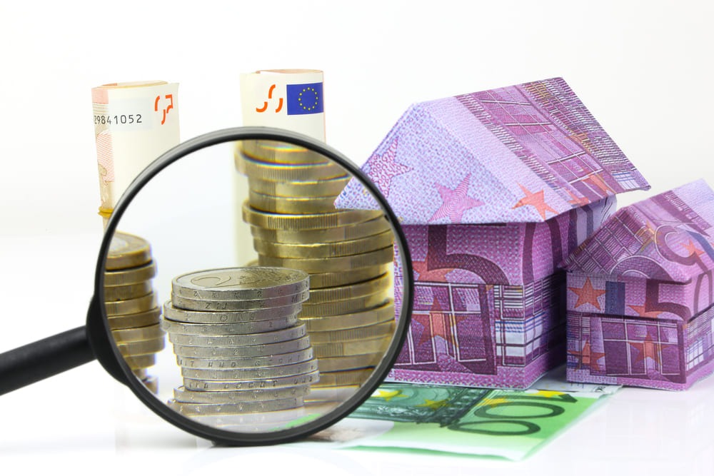 Lupe vor einem Haus aus Geld | Immobilienfinanzierung | FKS Immobilien